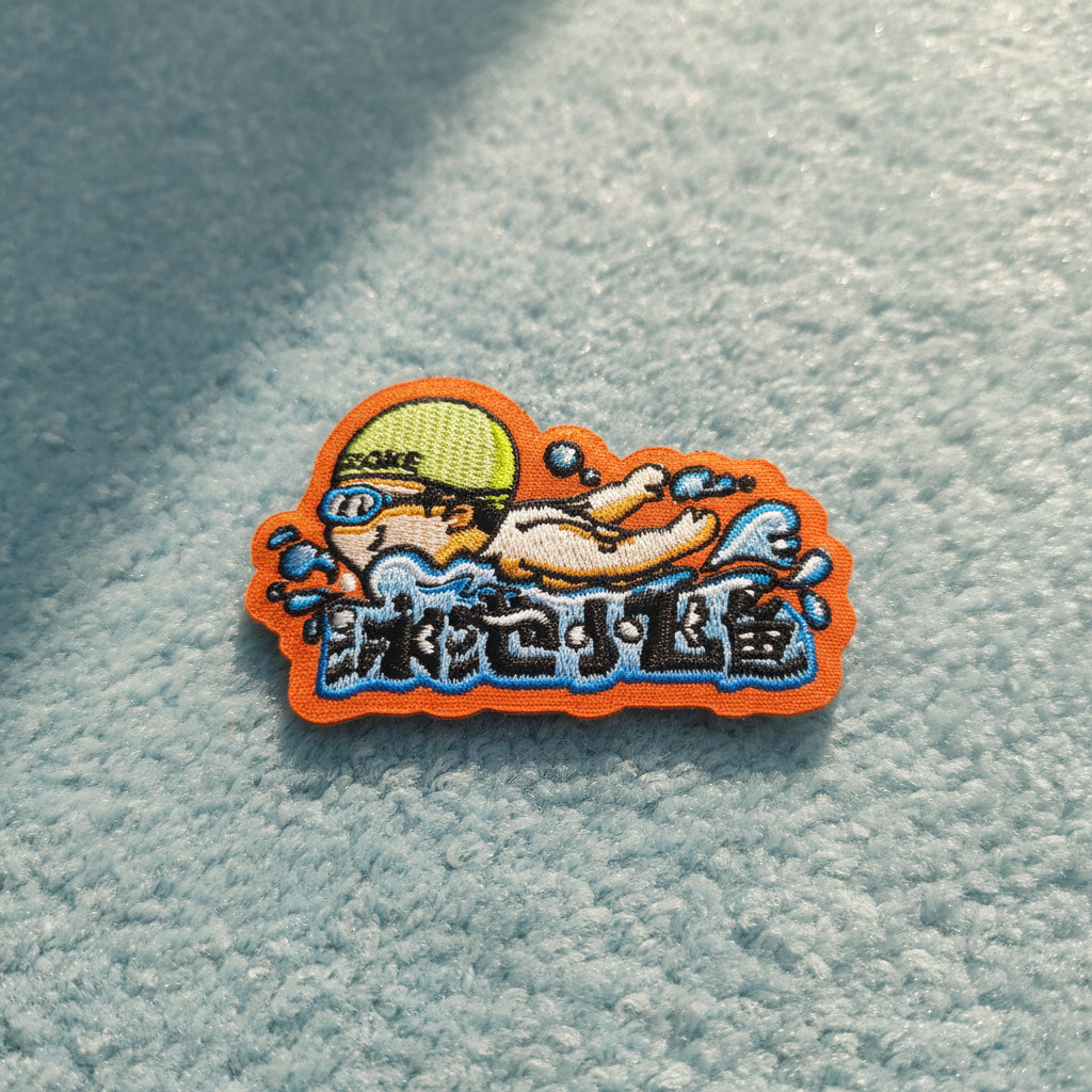 Colorful embroidered patch held by a hand on a white background